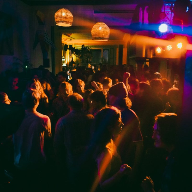 Dark photo of a crowd of people enjoying a live band.