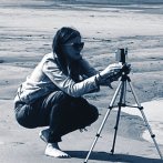 A woman using a camera on a forecourt