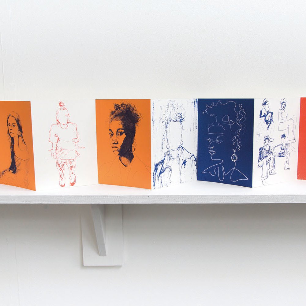 A fold out book of drawings on a shelf