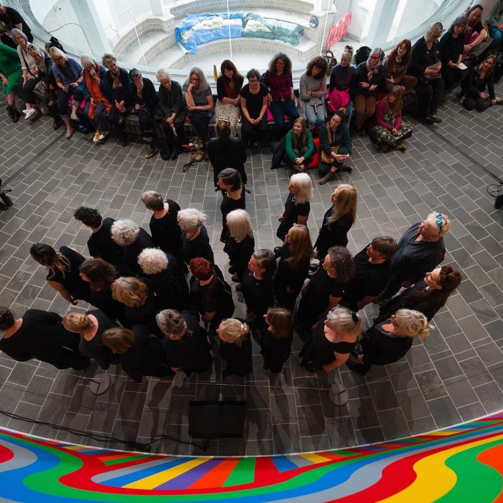 Birdseye view of a performance that 27 people wearing black are doing