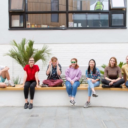 Student smiling and sitting on wall in Fox cafe.