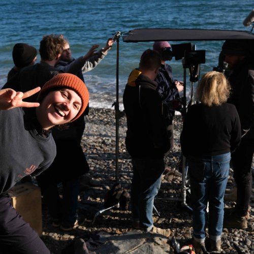 A student poses in front of the film set for Mab Hudel