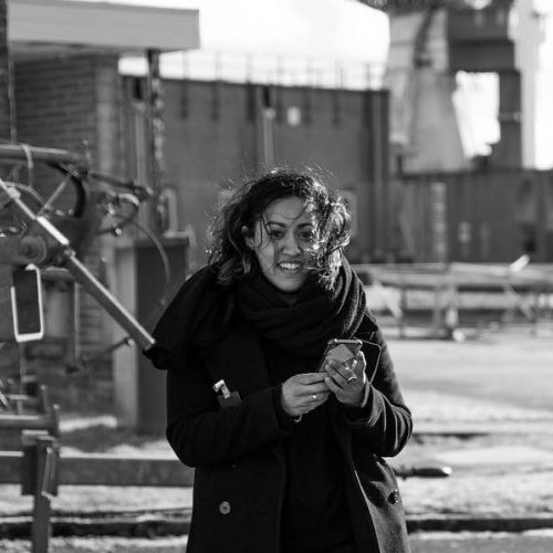 Black and white image of woman in a black coat smiling