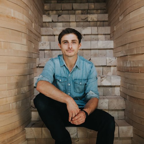 Falmouth University alumni Tom Raffield sitting on wooden steps