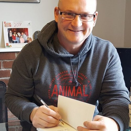 Adrian Martin poses as he signs at book