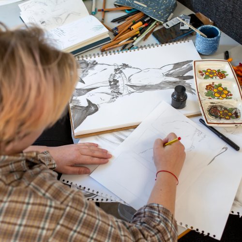 Falmouth Illustration student at cluttered desk drawing a rabbit