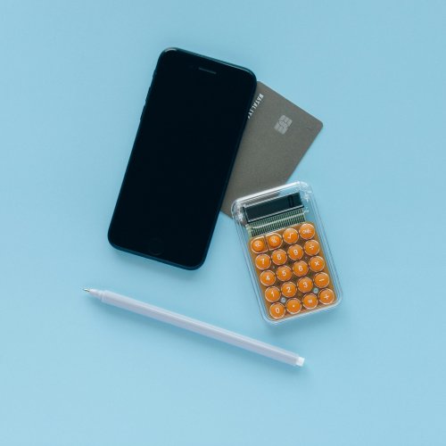 Phone, calculator and bank card on blue background