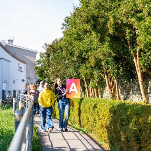 A group of people walking outside at a Falmouth University Open Day