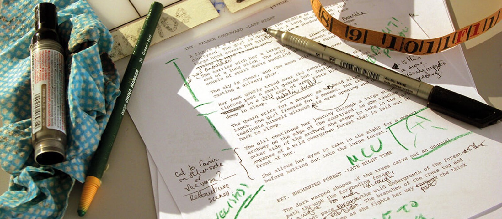 A printed piece of paper with green ink annotations and pens