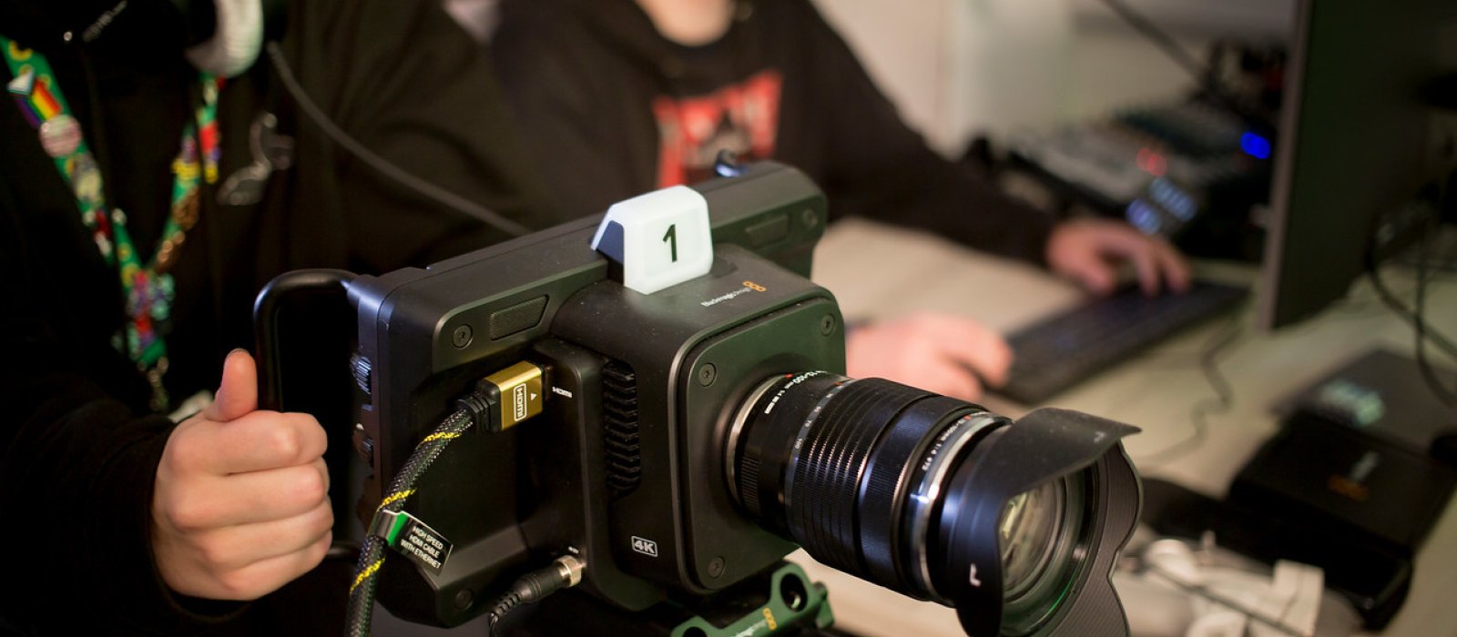 A Falmouth University student operating a camera with a student in the background