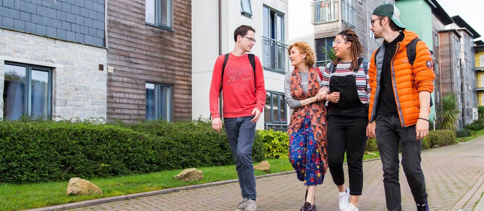 Students walking through Glasney Village with arms linked.