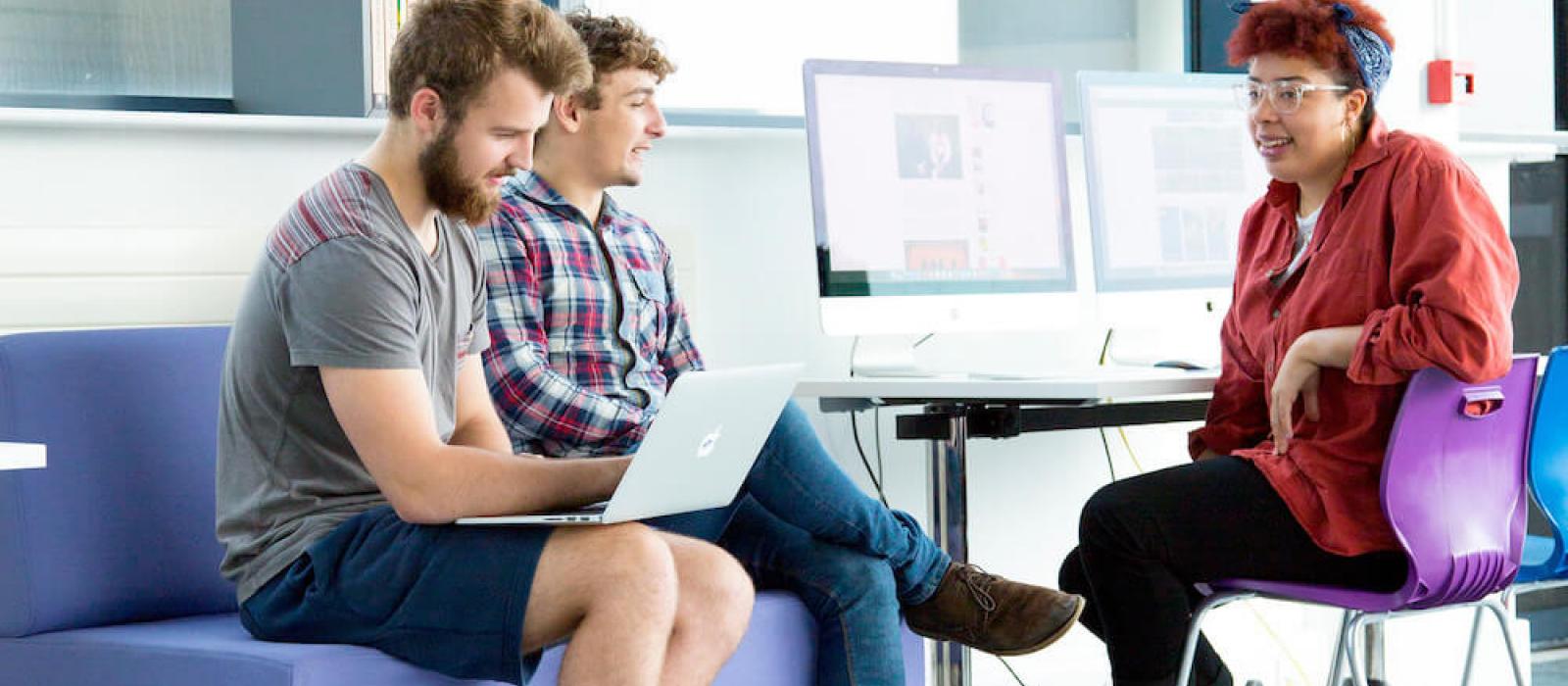 Three Falmouth University students seated talking