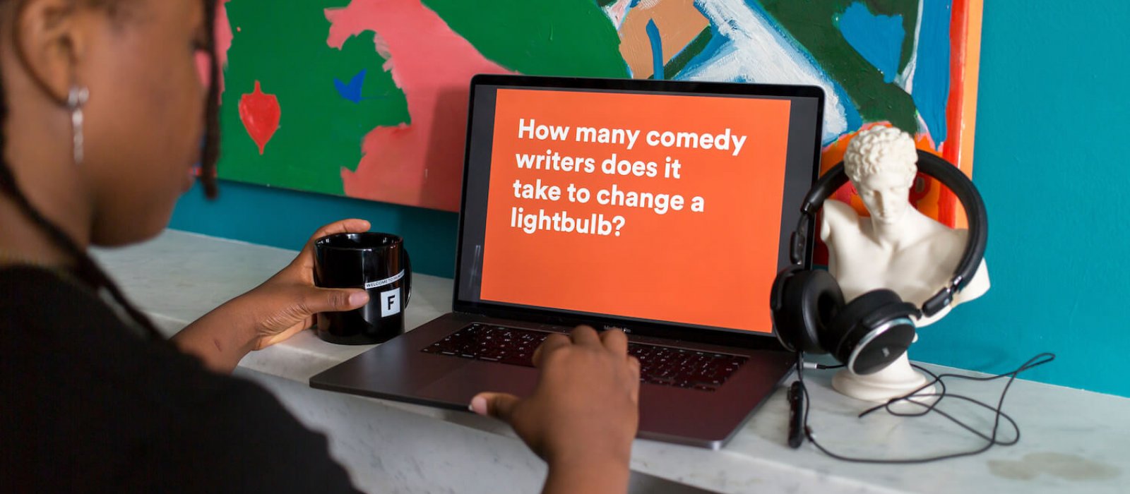 A Falmouth University student at a laptop with an orange screen