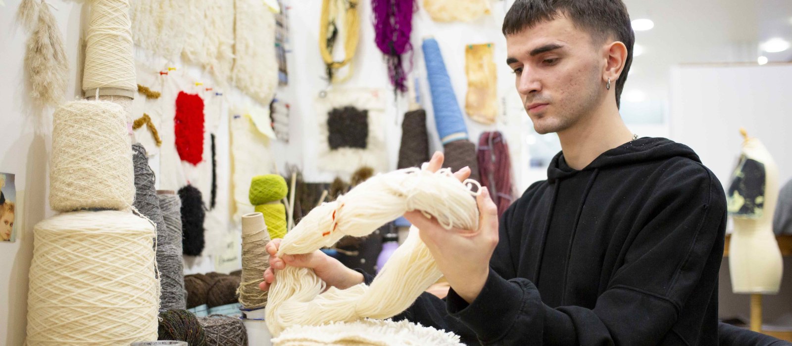 Student handling wool in textile studio