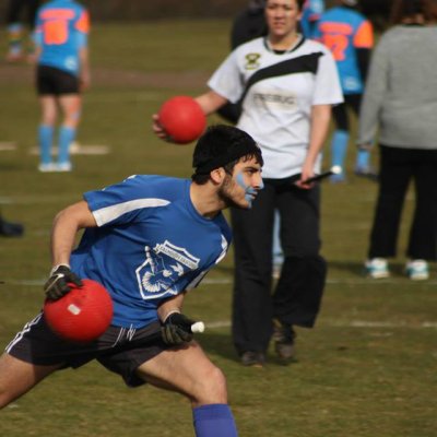 Falmouth University student dressed in blue, playing in the Quidditch society