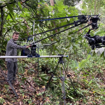 Matt Roseveare stands next to a camera crane to film pangolins in the Taiwan jungle.