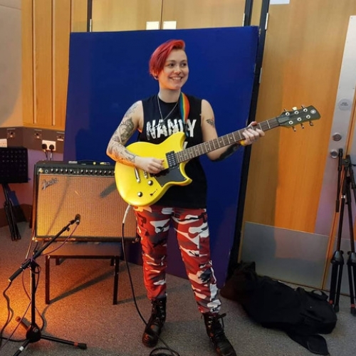Harri Betsworth performing with her guitar