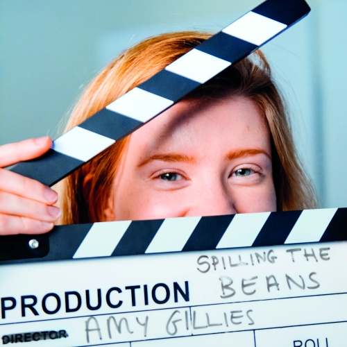 Student, Amy Gillies, peeking though a clapperboard.