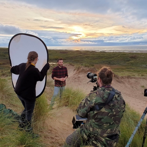 Students filming on beach