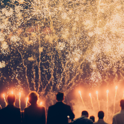 A group of people looking at a huge orange firework display