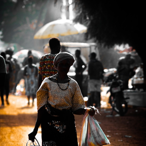 Woman in African dress carrying bags