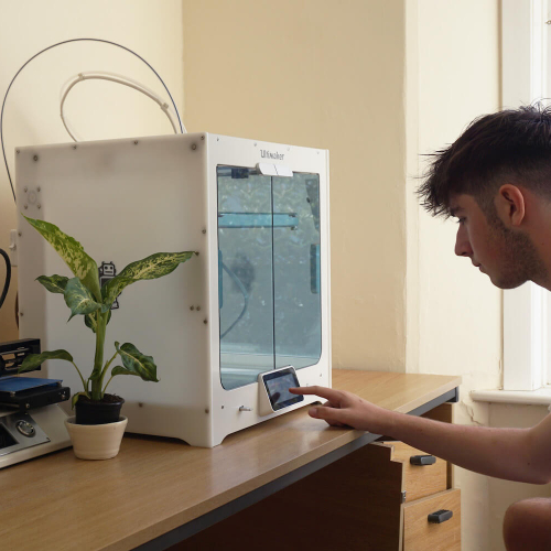 A Falmouth University Sustainable Product Design student with a 3D printer