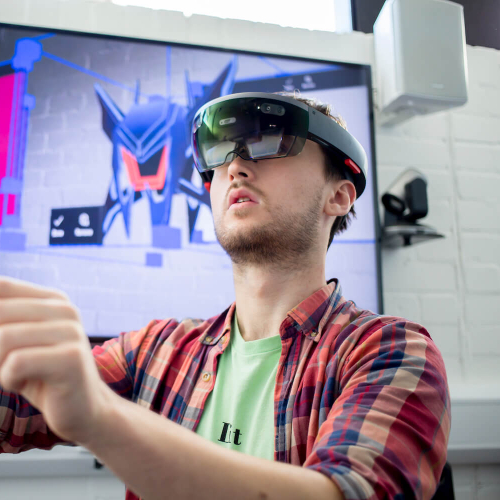 A Falmouth University student wearing a VR headset and a checked shirt