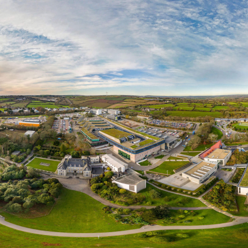 A wide angle aerial shot of Penryn campus with buildings and fields.