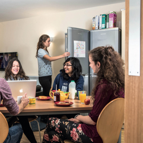 A group of Falmouth University students sat round a table having breakfast in university halls