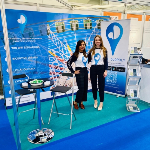 Tanuvi and Erin Data Duopoly Two women standing together in a blue Data Duopoly exhibition stand