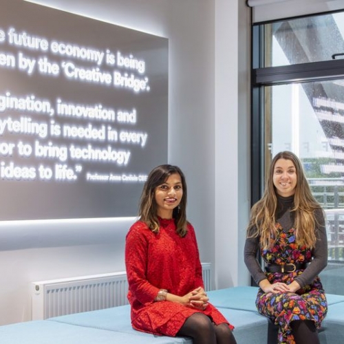 Tanuvi And Erin from Data Duopoly Two women seated in front of a a screen with white text