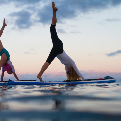 Falmouth University students doing yoga on paddle boards