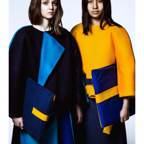Models in structured outfits of navy, yellow and blue.