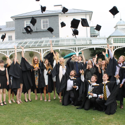 Creative Events Management students graduating from Falmouth and throwing mortar boards into the air