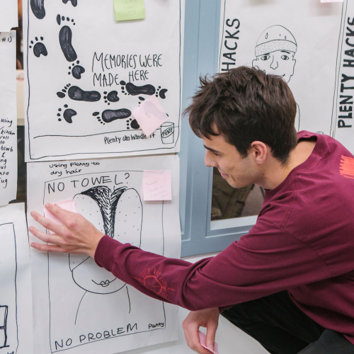 Falmouth Creative Advertising student sticking post-it on ideas wall