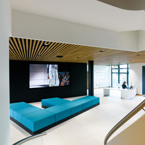 Stylish interior at the Creative Bridge with a blue sofa and digital screen