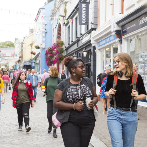 Group of students walking through Falmouth high street.