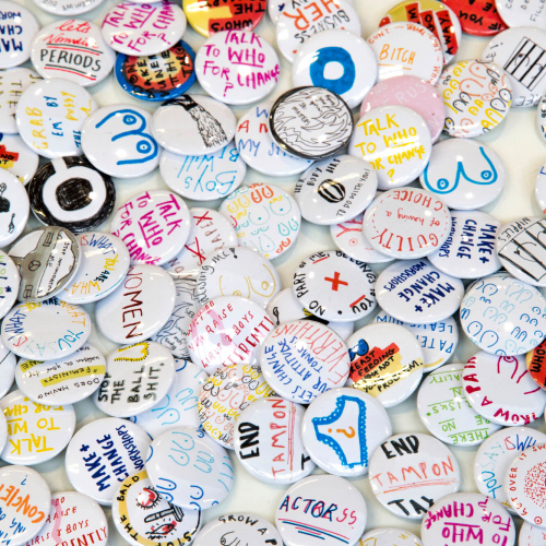 Large collection of badges with hand drawn messages.