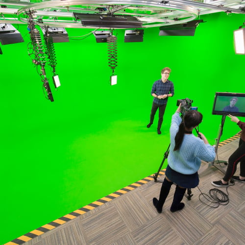 Television students presenting and filming with a green screen in studio at Falmouth University