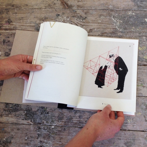 Hand opening book with illustration of victorian couple kissing inside a red prism structure.