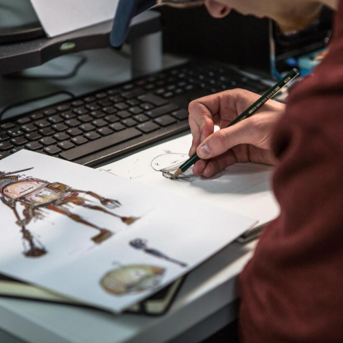 Close up of Falmouth University Game Art student hands sketching character design.