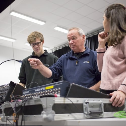 Falmouth University technician showing two people how to use recording equipment