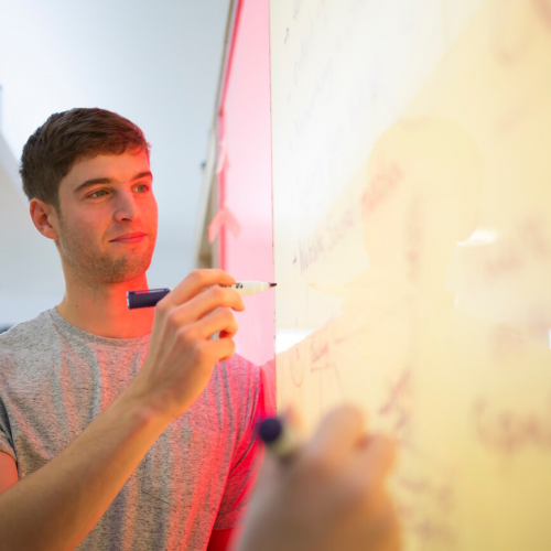 Falmouth University business student writing on a white board
