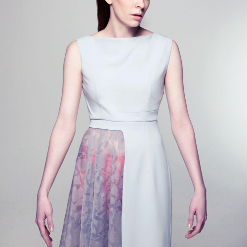 Female model in pale dress with half of the skirt patterned.