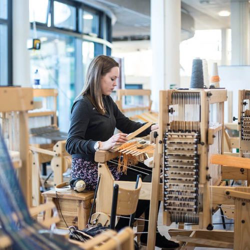 Textile Design student working on loom in studio at Falmouth University