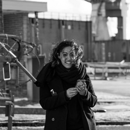 Black and white image of woman in a black coat smiling