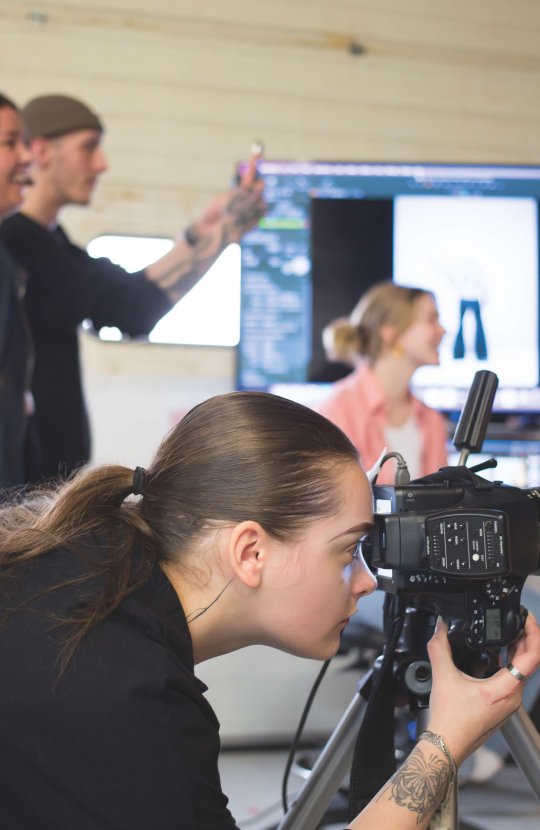 Fashion photography student taking photo in studio