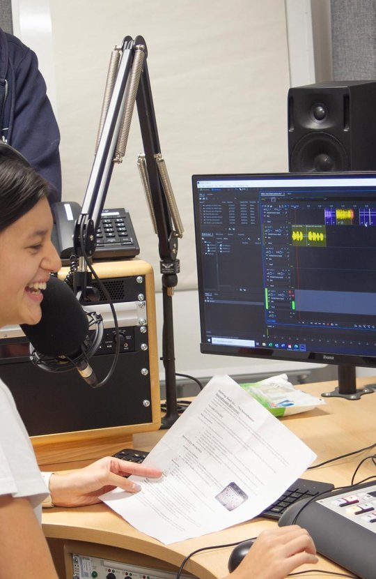 A female student working in an radio studio at Falmouth University